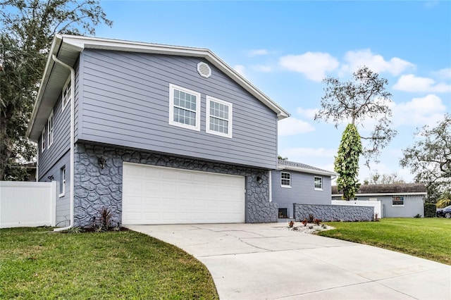 view of property featuring a front yard and a garage