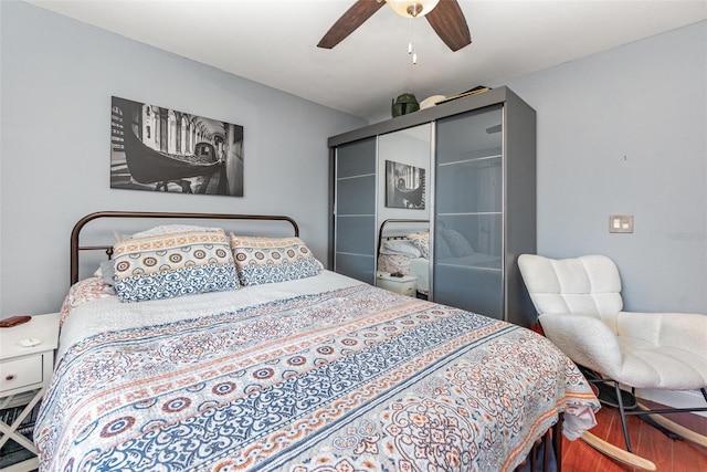 bedroom with hardwood / wood-style floors, a closet, and ceiling fan