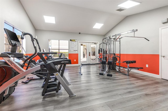 exercise room with hardwood / wood-style flooring and vaulted ceiling