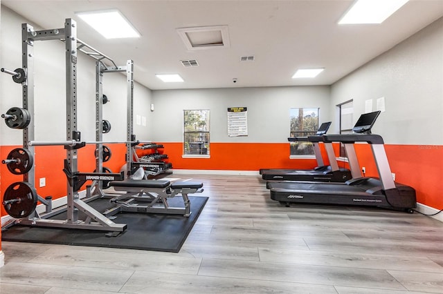 exercise room with light wood-type flooring