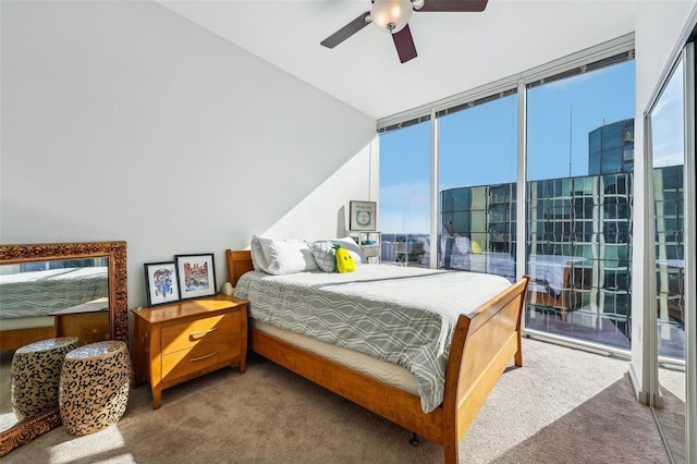 bedroom featuring ceiling fan, expansive windows, and carpet floors