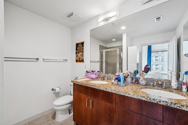 bathroom featuring tile patterned floors, toilet, vanity, and walk in shower