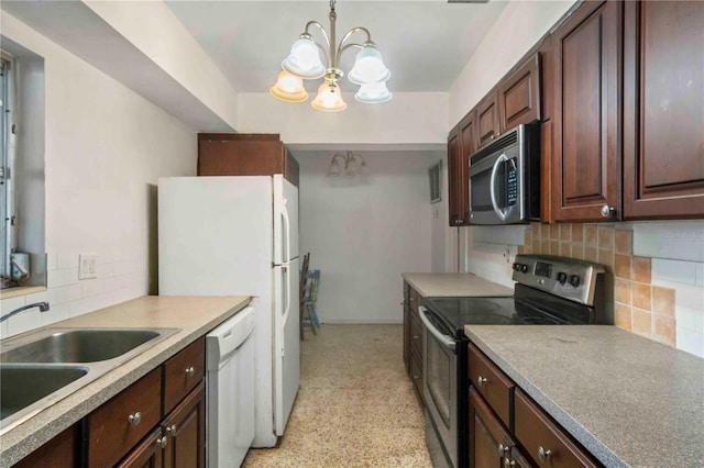 kitchen with tasteful backsplash, stainless steel appliances, sink, a notable chandelier, and hanging light fixtures