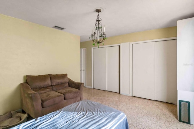 bedroom with two closets and a chandelier