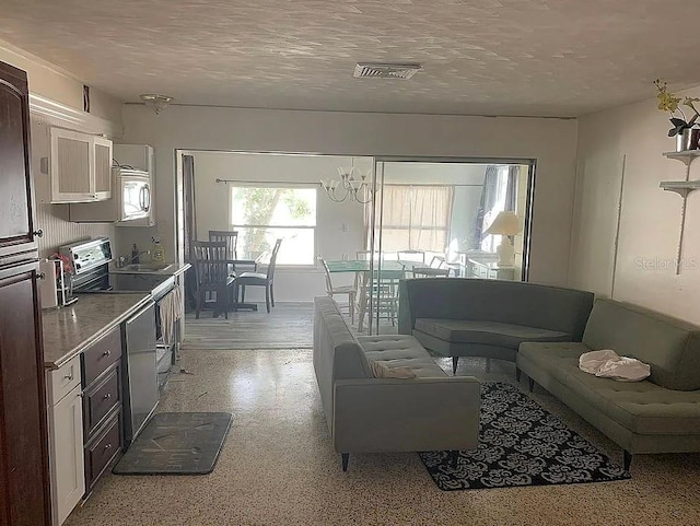 2695 S E Ave, Sarasota, FL 34239 - living area featuring dark aggregate flooring, a chandelier, and a textured ceiling