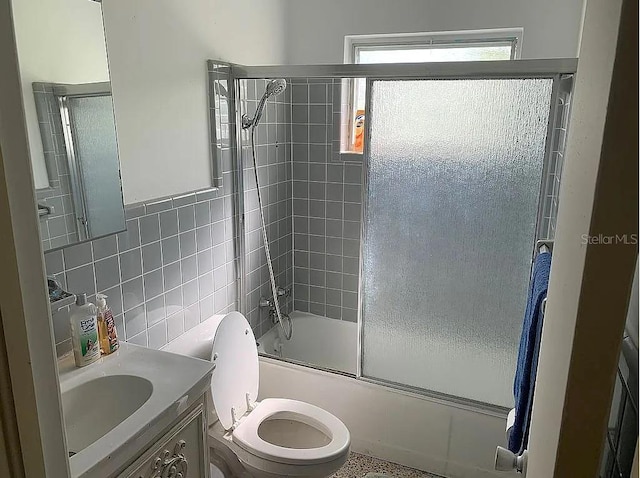 2695 S E Ave, Sarasota, FL 34239 - bathroom featuring vanity, shower / bath combination with glass door, and tile walls