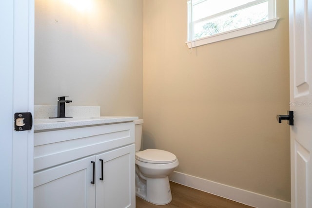 bathroom with wood-type flooring, vanity, and toilet