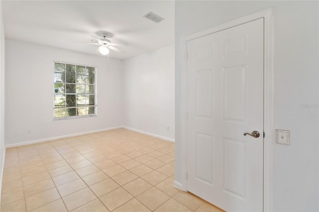 spare room with ceiling fan and light tile patterned floors