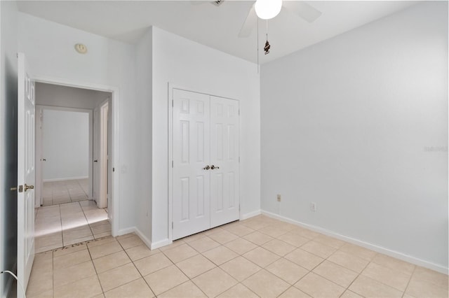 unfurnished bedroom featuring light tile patterned floors, a closet, and ceiling fan