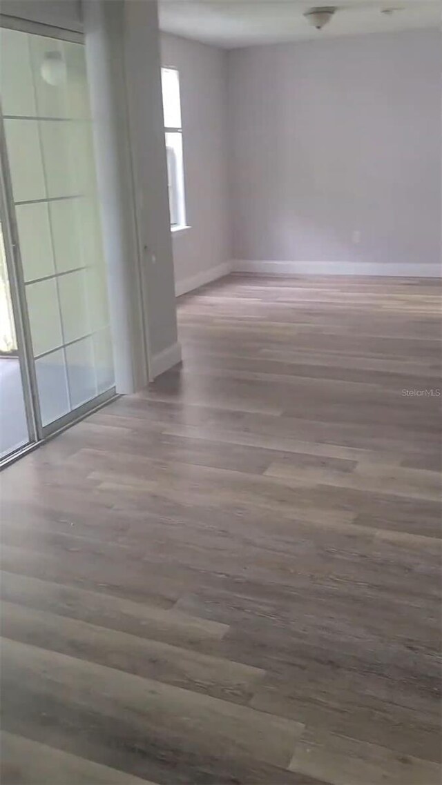 empty room with baseboards and wood finished floors