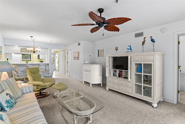 living room with a textured ceiling, light colored carpet, and ceiling fan with notable chandelier