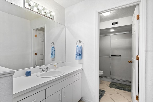 bathroom with tile patterned floors, an enclosed shower, vanity, a textured ceiling, and toilet