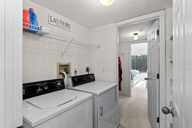 laundry area featuring light carpet, a textured ceiling, and independent washer and dryer