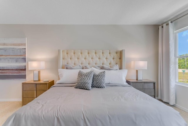 bedroom featuring light carpet and multiple windows