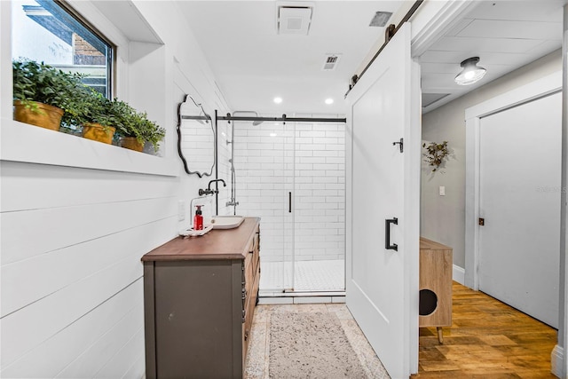 bathroom with vanity, wood-type flooring, and a shower with shower door