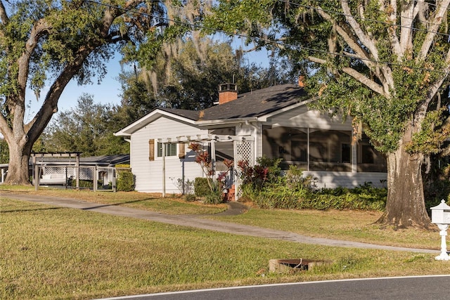 view of front facade featuring a sunroom and a front lawn