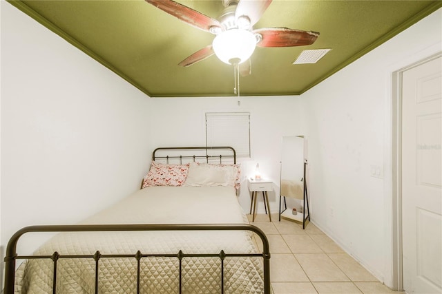 bedroom featuring light tile patterned floors, crown molding, and ceiling fan