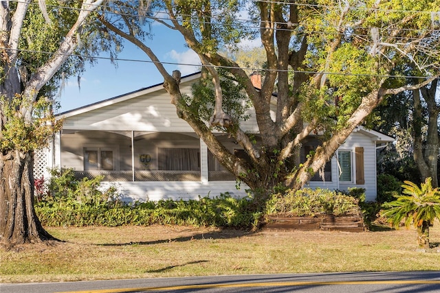 view of property exterior featuring a sunroom and a yard