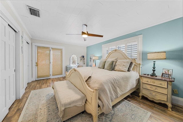 bedroom with hardwood / wood-style flooring, ceiling fan, and ornamental molding