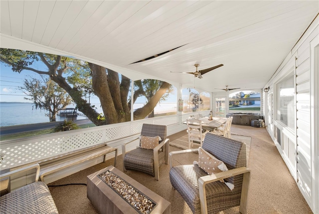 view of patio with an outdoor living space with a fire pit, ceiling fan, and a water view