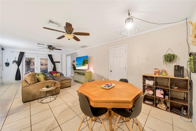 dining area with french doors, ceiling fan, ornamental molding, and light tile patterned floors