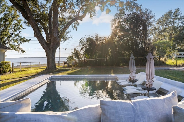 view of pool featuring a water view and a yard