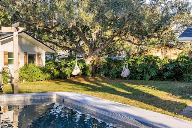 view of pool featuring a lawn