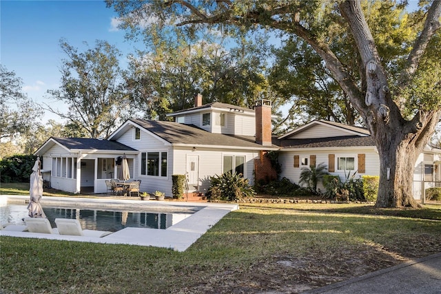 rear view of property with a patio and a lawn