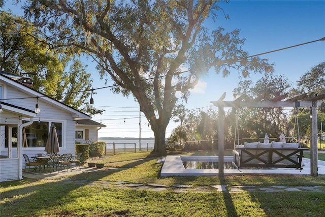 view of yard with a pergola, a patio area, and a water view