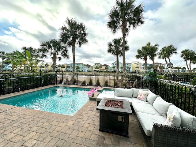 view of swimming pool with a patio area and an outdoor living space with a fire pit