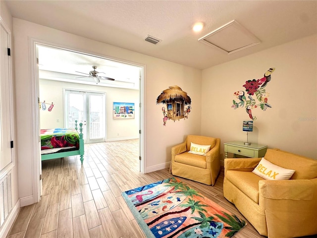 sitting room with hardwood / wood-style flooring and ceiling fan