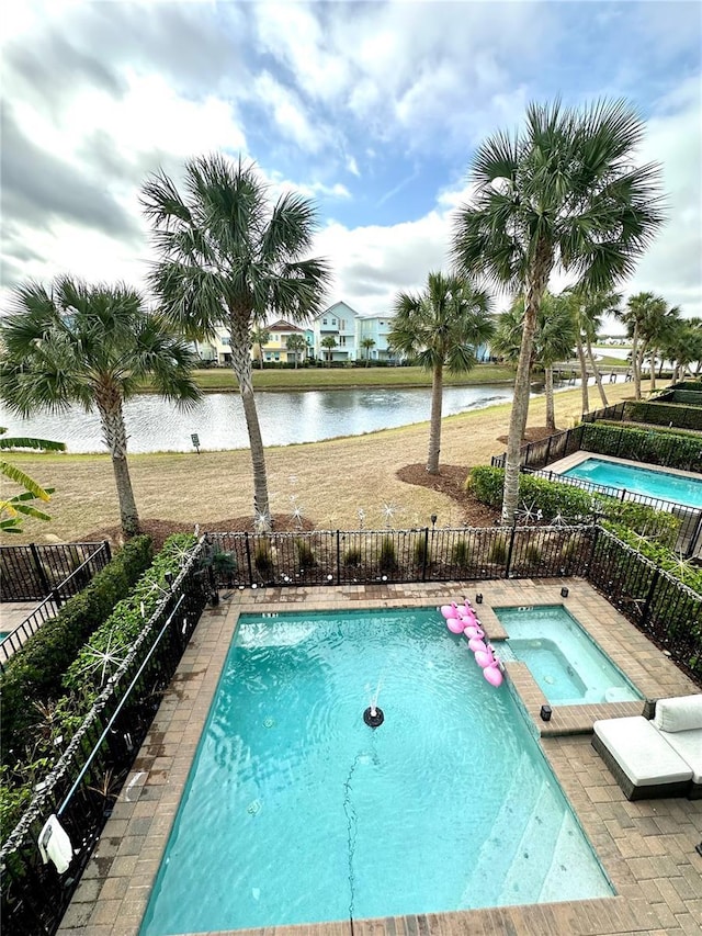 view of pool featuring an in ground hot tub and a water view