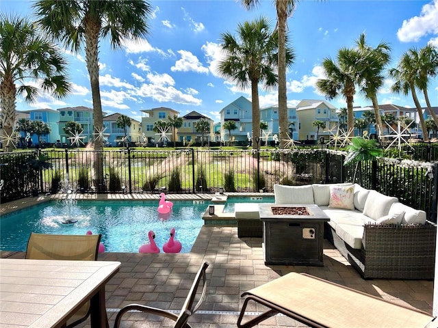 view of pool featuring an outdoor living space with a fire pit and a patio