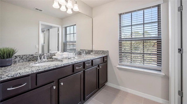 bathroom with tile patterned floors, vanity, and a healthy amount of sunlight