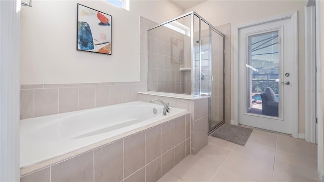 bathroom with tile patterned flooring, shower with separate bathtub, and a wealth of natural light