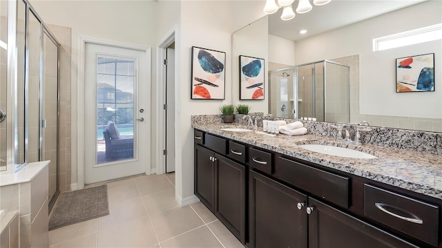 bathroom featuring tile patterned flooring, vanity, a healthy amount of sunlight, and walk in shower