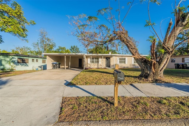 single story home featuring a carport and a front lawn