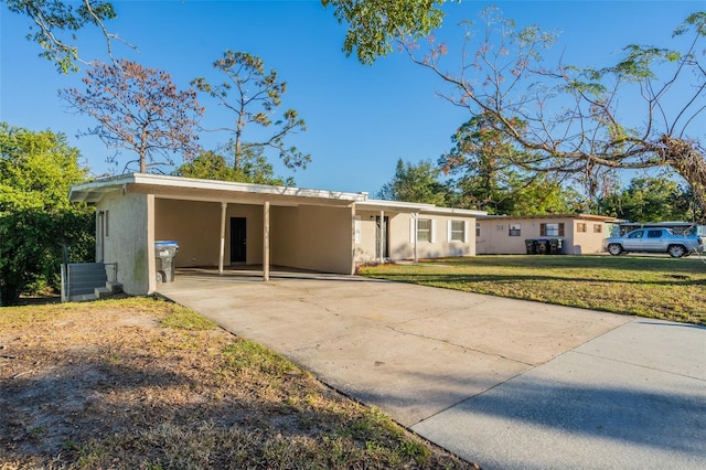 ranch-style home featuring a carport and a front lawn