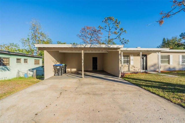 back of property with a carport and a yard