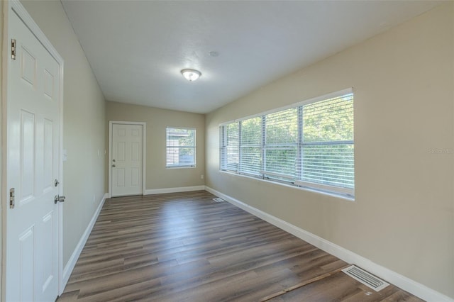 unfurnished room with dark wood-type flooring