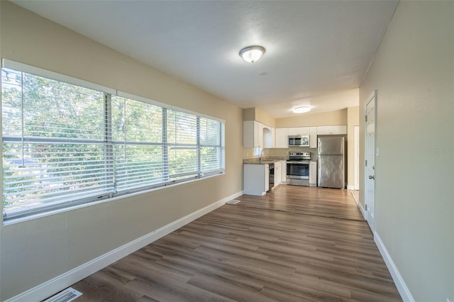 interior space with sink, dark hardwood / wood-style flooring, white cabinetry, and stainless steel appliances