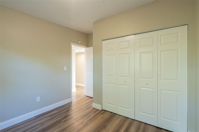 unfurnished bedroom featuring dark hardwood / wood-style flooring and a closet