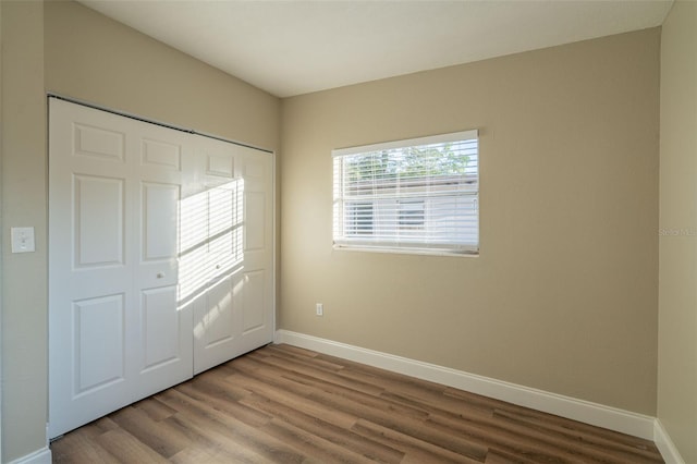 unfurnished bedroom with a closet and hardwood / wood-style floors