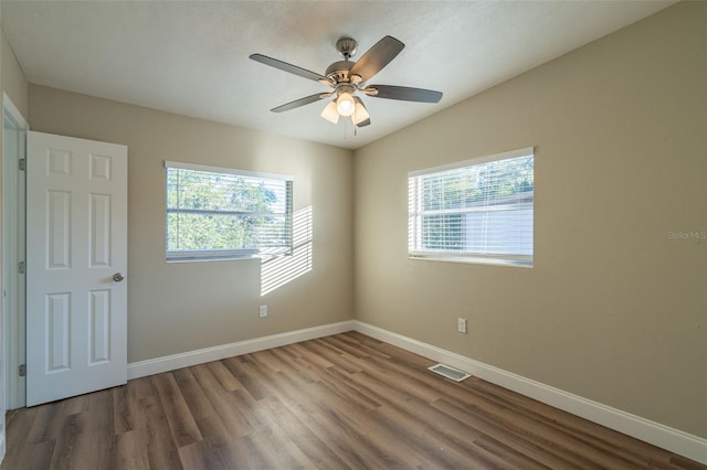 spare room featuring ceiling fan and dark hardwood / wood-style floors