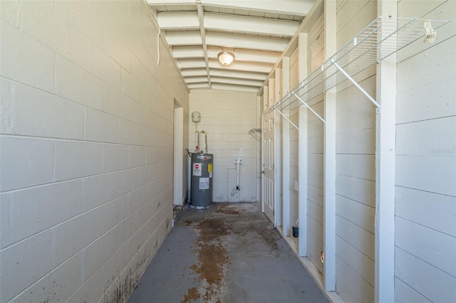 hallway with water heater and concrete flooring