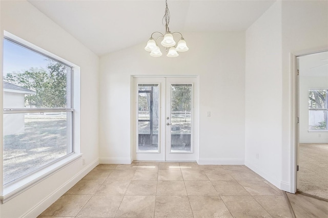 unfurnished dining area with a notable chandelier, vaulted ceiling, light tile patterned floors, and french doors