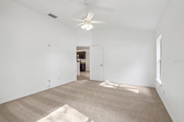 empty room with ceiling fan, lofted ceiling, and light carpet