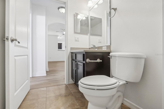 bathroom with ceiling fan, toilet, wood-type flooring, and vanity