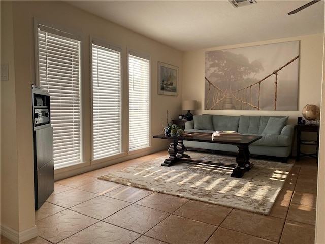 tiled living room with ceiling fan