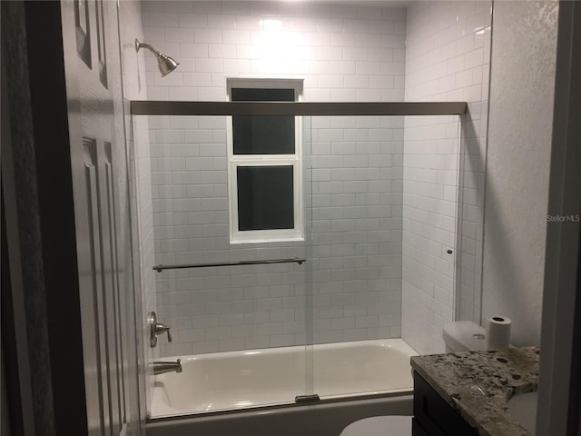 full bathroom featuring vanity, toilet, and bath / shower combo with glass door